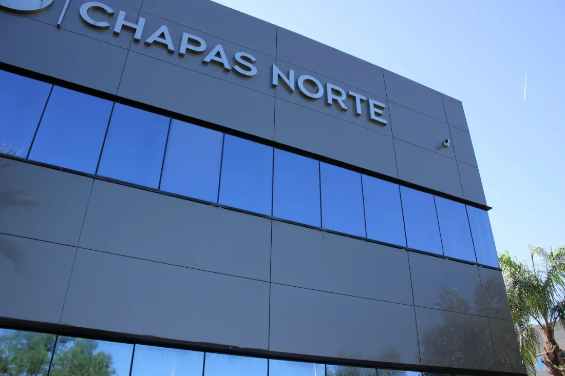 Fachada de vidrio de la nave de Chapas Norte con el rótulo de la empresa, tras la limpieza.